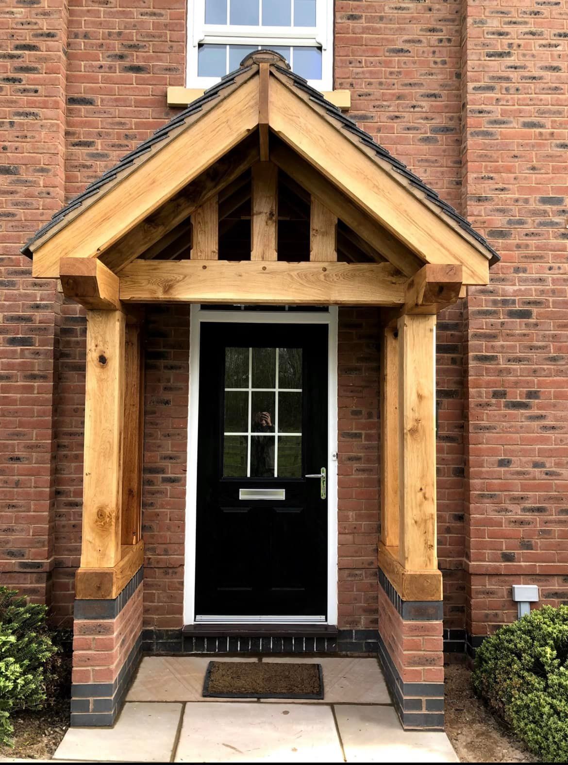 Gabled oak porch with black door